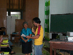 Dr. Titos A, O. Quibuyen presenting a plaque of appreciation to Dr. Rita P. Laude of 